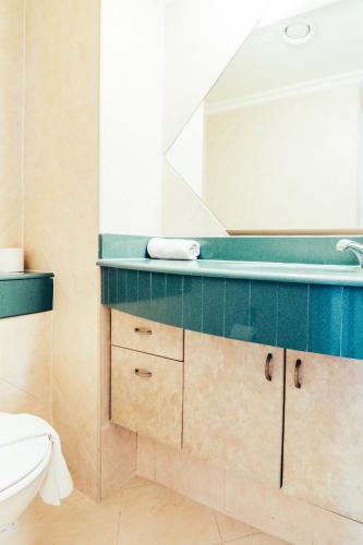 a bathroom with a sink and a toilet and a mirror at Almog Haifa Israel Apartments מגדלי חוף הכרמל in Haifa