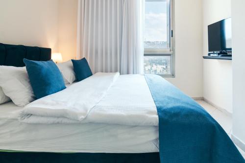 a large bed in a room with a window at Almog Haifa Israel Apartments מגדלי חוף הכרמל in Haifa