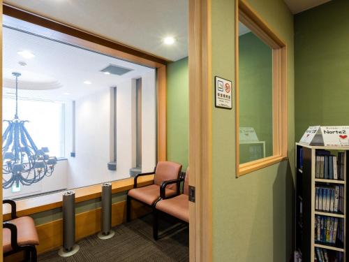 a waiting room with two chairs and a window at Business Inn Norte 2 in Sapporo