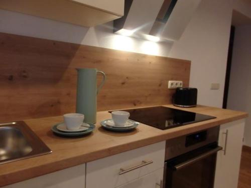 a kitchen counter with two cups and a sink at Ferienwohnungen Schwöblehen in Schönau am Königssee