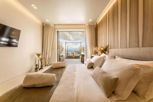a bedroom with a large bed with white pillows at Avgoustos Suites Naxos in Naxos Chora