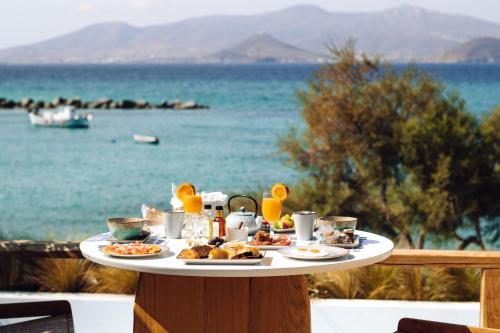 a table with food on it with a view of the water at Avgoustos Suites Naxos in Naxos Chora