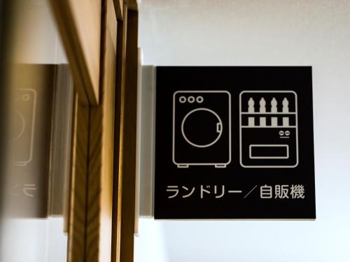 a sign on the side of a door with writing on it at Business Inn Norte 2 in Sapporo