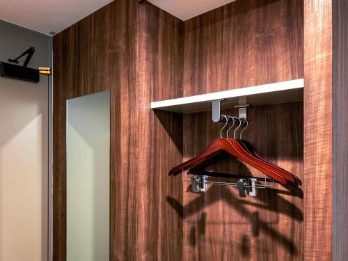 a bathroom with a mirror and a red hanger at Business Inn Norte 2 in Sapporo