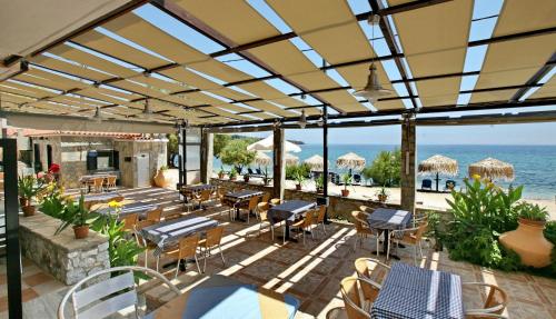 an outdoor patio with tables and chairs and the ocean at 9 Musses Studios in Skala Mistegnon