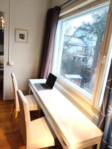 a laptop sitting on a desk next to a window at Reipas in Kotka