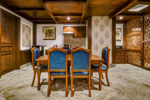 a dining room with a wooden table and chairs at Lemon Tree Premier, Dwarka in Dwarka
