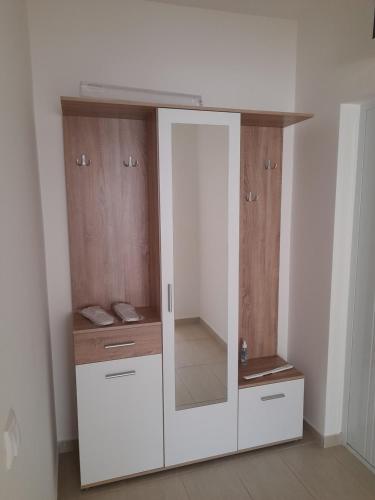 a white cabinet with a mirror in a room at Apartman 8 in Vrdnik
