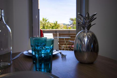 une table en bois avec un vase et un verre dans l'établissement Lecques, à Saint-Cyr-sur-Mer