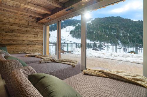 a living room with two couches and a large window at Berghotel Hauserbauer in Dorfgastein