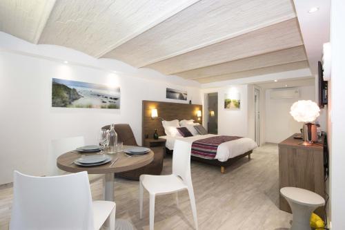 une chambre d'hôtel avec un lit, une table et des chaises dans l'établissement Cailloux, à Saint-Cyr-sur-Mer