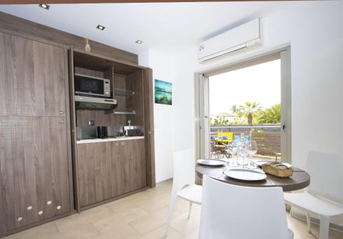 une cuisine et une salle à manger avec une table et des chaises dans l'établissement Rainette, à Saint-Cyr-sur-Mer
