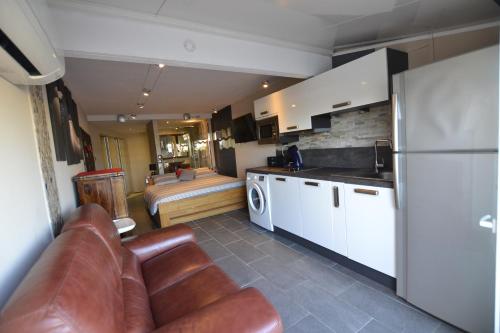 un salon avec un canapé et une cuisine dans l'établissement Studio Naturiste CAPTIVE Héliopolis FG 13, au Cap d'Agde