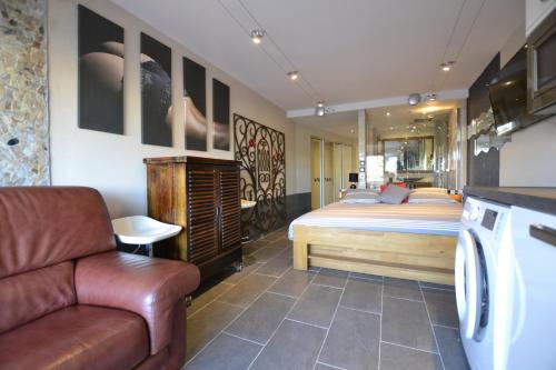 une chambre avec un lit et un canapé dans l'établissement Studio Naturiste CAPTIVE Héliopolis FG 13, au Cap d'Agde