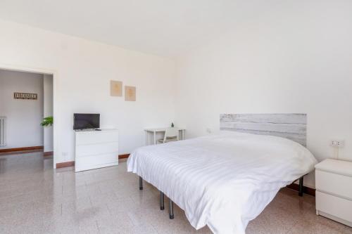 a white bedroom with a large bed and a television at Bonola M1 Bright & Functional Flat in Milan