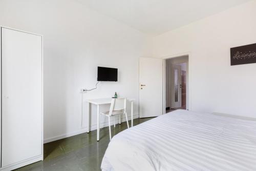 a white bedroom with a bed and a desk at Bonola M1 Bright & Functional Flat in Milan