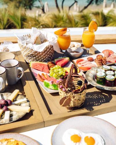 a table topped with plates of food and drinks at Avgoustos Suites Naxos in Naxos Chora
