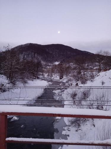 a fence with snow on top of a river at Садиба Федорчуків За рікою1 in Sheshory