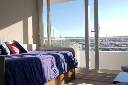 a bedroom with a bed and a large window at Espectacular atardecer porteño-Viña in Viña del Mar