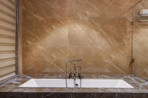 a bathroom with a bath tub with a sink at Lemon Tree Premier, Dwarka in Dwarka