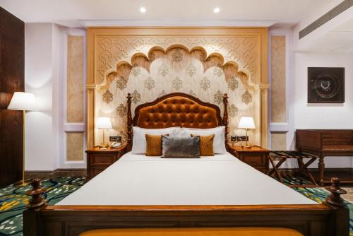 a bedroom with a large bed with a large headboard at Lemon Tree Premier, Dwarka in Dwarka