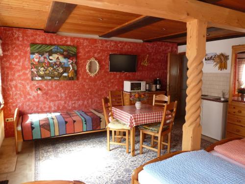 a room with a table and a bed and a kitchen at Gästezimmer am Märchenbrunnen in Lockwitz