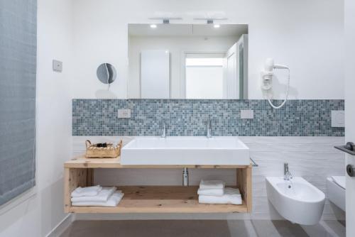 a white bathroom with a sink and a mirror at Relais Barchessa Molon in Campo di Pietra