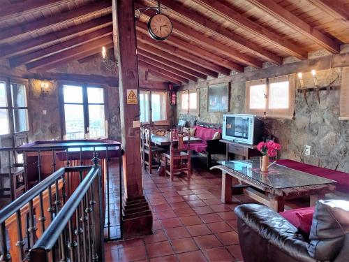ein Wohnzimmer mit einem Tisch und einer Uhr an der Wand in der Unterkunft Casa Rural Menta y Canela in Tórtoles