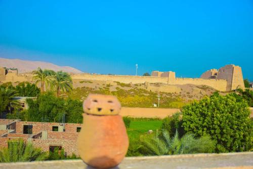 a brick pot sitting on a ledge with a castle in the background at Rose Guest House in Luxor