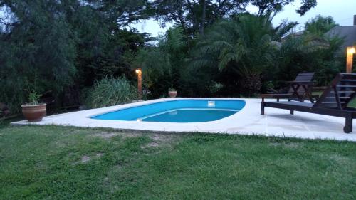 uma piscina num quintal com um banco em El Piul em Valle Hermoso