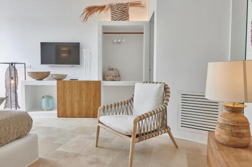 a living room with a chair and a tv at Musae al Mare in Polignano a Mare