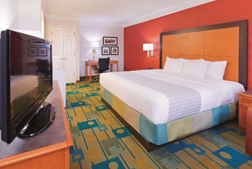 a hotel room with a bed and a flat screen tv at Baymont by Wyndham Lubbock - Downtown Civic Center in Lubbock