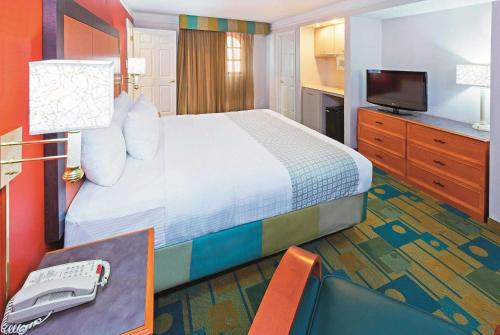 a hotel room with a large bed and a phone at Baymont by Wyndham Lubbock - Downtown Civic Center in Lubbock