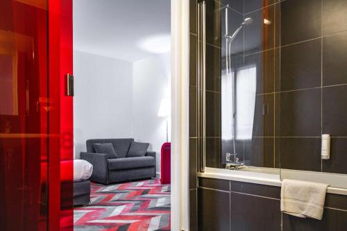 een badkamer met een bank en een stoel in een kamer bij Best Western Hotel San Benedetto in Cholet