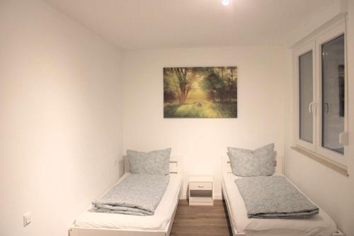 Zimmer mit 2 Betten und einem Bild an der Wand in der Unterkunft Work & Stay in Jena in Neuengönna