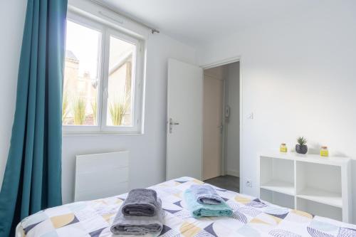une chambre avec un lit avec des serviettes dessus dans l'établissement Appartement COSY Danton 2 chambres, au Havre