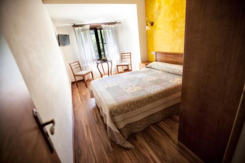 a bedroom with a bed and a table and chairs at Hotel Covadonga in Cangas de Onís