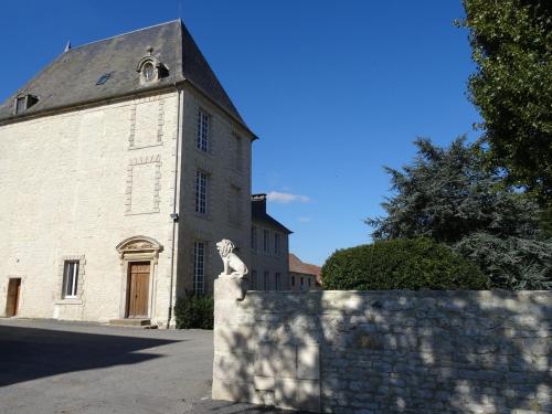 eine Kirche mit einer Statue vor einem Gebäude in der Unterkunft Le Seigneur de Bons in Bons-Tassily