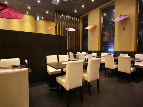 a dining room with tables and white chairs and umbrellas at APA Hotel Asakusa Kuramae in Tokyo