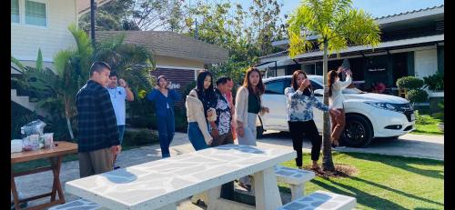a group of people standing in front of a table at Panutsaya Homestay in Wang Nam Khieo