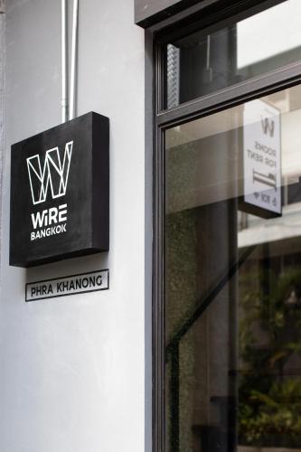 a sign on the side of a building with a window at WiRE BANGKOK PRAKHANONG in Amphoe Phra Khanong