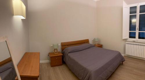 Nonno 'Drea guest house في كاستيغليون ديلا بيسكايا: غرفة نوم صغيرة بها سرير ومداخلة ليلتين