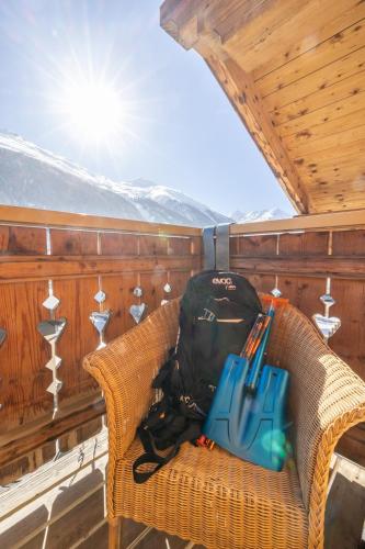 a backpack and a bag sitting in a wicker chair at Hotel Alegra in Livigno
