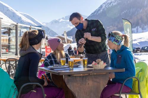a man sitting at a table with a group of people at Hotel Alegra in Livigno