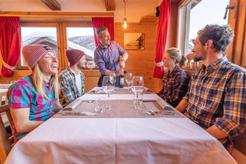 a group of people sitting around a table in a restaurant at Hotel Alegra in Livigno