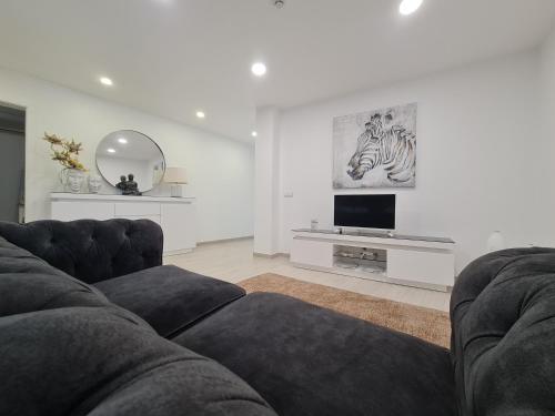 a living room with a couch and a flat screen tv at Espírito Santo - AL in Ponta Delgada