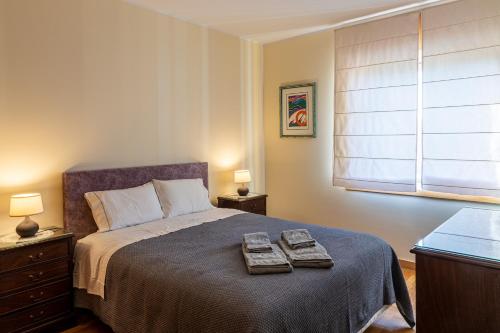 a bedroom with a bed with two towels on it at Preciosa Apartment by MP in Vila Nova de Gaia