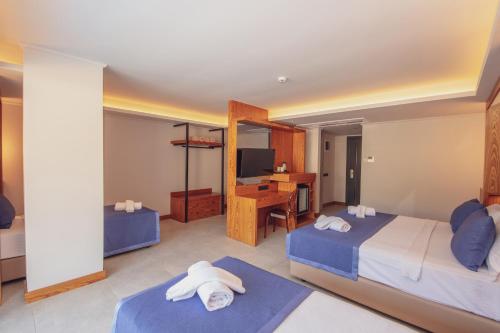 a hotel room with two beds and a desk at Orka World Hotel & Aquapark in Oludeniz