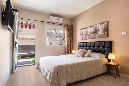 a bedroom with a bed and a tv and a window at Estudio con Balcón Estrella de Mar in Los Abrigos