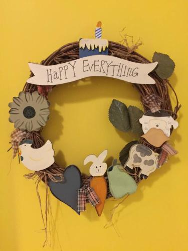 a wreath with a happy everything sign on a wall at La Porte Rouge in Pézenas